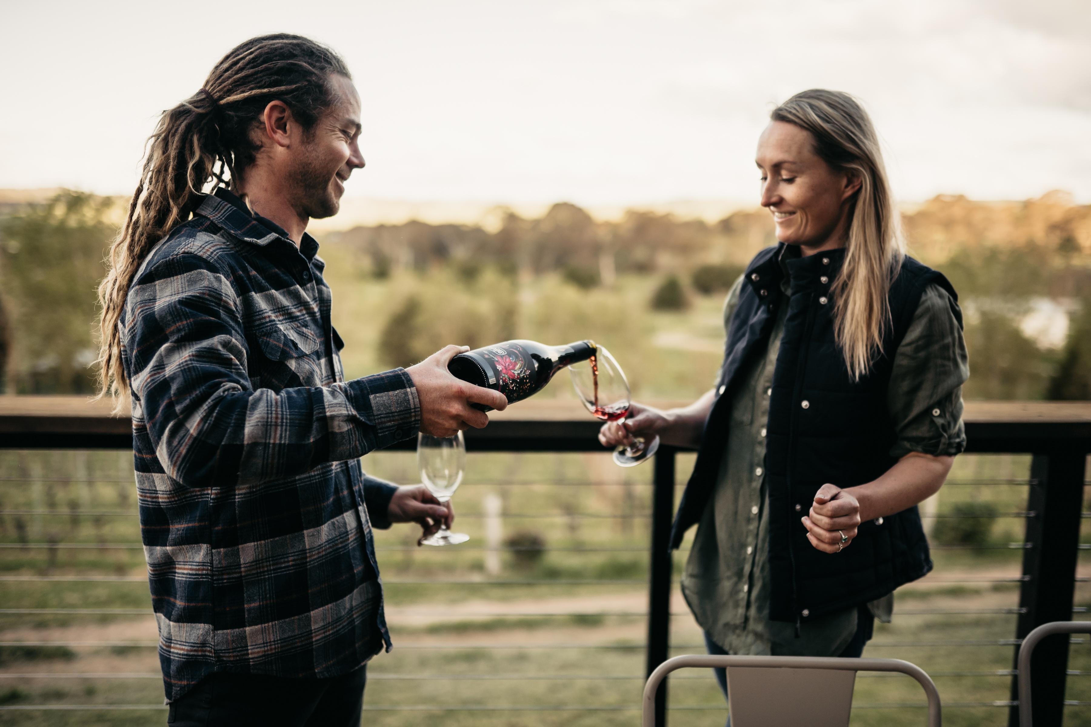 A man and  woman enjoying a bottle of ChaLou Wines at the balcony 